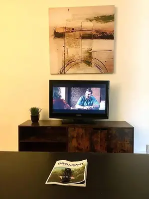 a flat screen tv sitting on top of a table at Fully furnished 2 bedroom unit, downtown, near subway, 32 days minimum in Montréal
