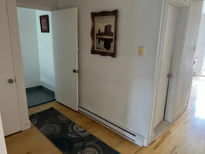 a hallway with white walls and a mirror on the wall at Chambres à louer in Montréal