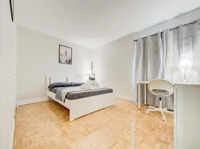 a white bedroom with a bed and a desk at Cozy 2-Bedroom à Plateau-Mont-Royal in Montréal