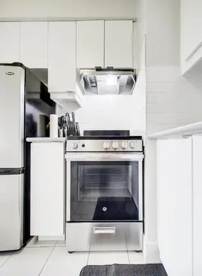 a kitchen with white cabinets and an oven at Cozy 2-Bedroom à Plateau-Mont-Royal in Montréal