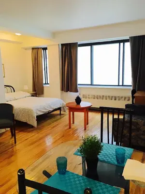 a living room with a bed and a table at Stylish Montreal Apartment Comfortable Stay in the Golden Square Mile in Montréal