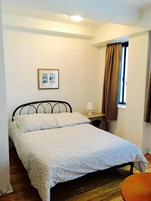 a bedroom with a bed with a blue blanket at Stylish Montreal Apartment Comfortable Stay in the Golden Square Mile in Montréal