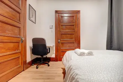 a bedroom with a bed and a chair and a door at Great 3B unit on Saint-Urbain in Montréal