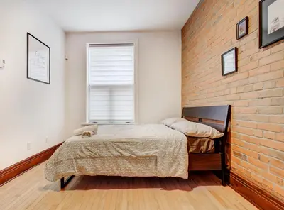 a bedroom with a bed and a brick wall at Great 3B unit on Saint-Urbain in Montréal