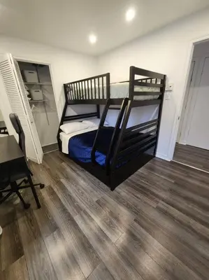 a bedroom with a bunk bed and a wooden floor at Perle Urbaine Chic et confort in Longueuil