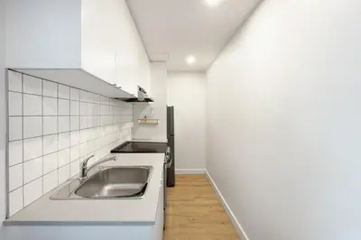 a kitchen with a sink and white cabinets at Appartements Dorchester in Montréal