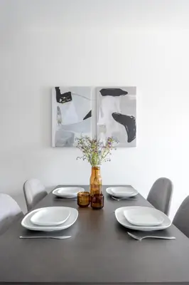 a black table with white plates and a vase with flowers at Appartements Dorchester in Montréal