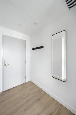an empty room with a mirror and a door at Appartements Dorchester in Montréal