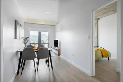 a dining room with a table and chairs and a bedroom at Appartements Dorchester in Montréal