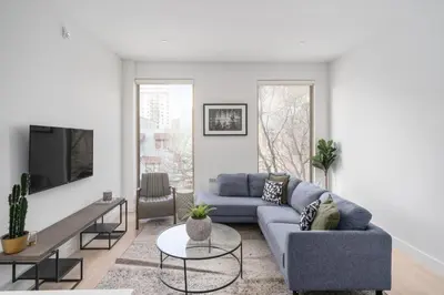 a living room with a blue couch and a tv at The S&D Apartments in Montréal