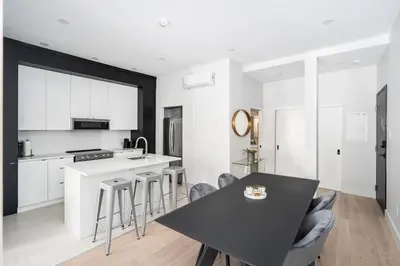 a kitchen with a black table and some chairs at The S&D Apartments in Montréal