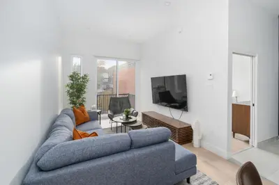 a living room with a blue couch and a tv at The S&D Apartments in Montréal