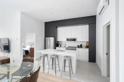 a kitchen with a white counter and a table and chairs at The S&D Apartments in Montréal