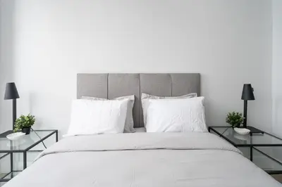 a bedroom with a large bed with white sheets and pillows at The S&D Apartments in Montréal