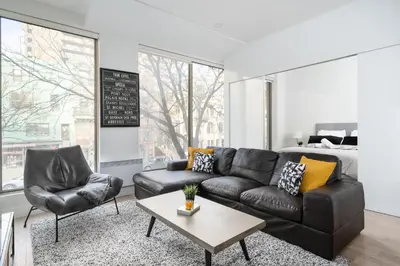a living room with a leather couch and a table at The S&D Apartments in Montréal