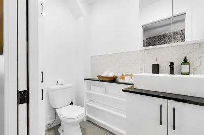 a white bathroom with a toilet and a sink at Boutique 4BR Luxury Residence 2 Floors Mile-End St-Laurent in Montréal