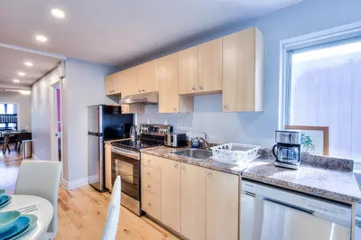 a kitchen with wooden cabinets and a counter top at Premier destination for Big Groups MTL Vacation and Nightlife in Montréal