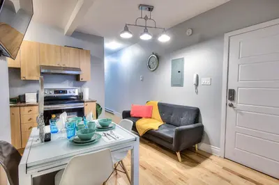 a kitchen and living room with a table and a couch at Premier destination for Big Groups MTL Vacation and Nightlife in Montréal