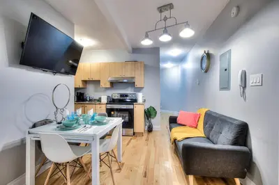 a living room with a table and a couch and a kitchen at Premier destination for Big Groups MTL Vacation and Nightlife in Montréal