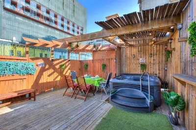 a deck with a hot tub and a table and chairs at Premier destination for Big Groups MTL Vacation and Nightlife in Montréal