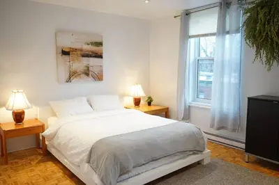 a bedroom with a white bed and a window at updated and cozy 2 bedroom unit, fully furnished, downtown, 32 days minimum in Montréal