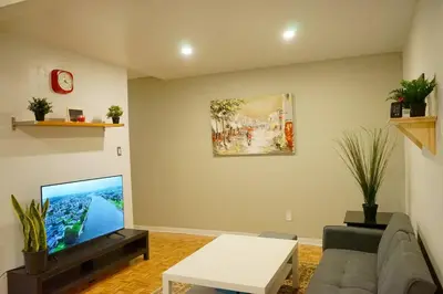 a living room with a couch and a flat screen tv at updated and cozy 2 bedroom unit, fully furnished, downtown, 32 days minimum in Montréal