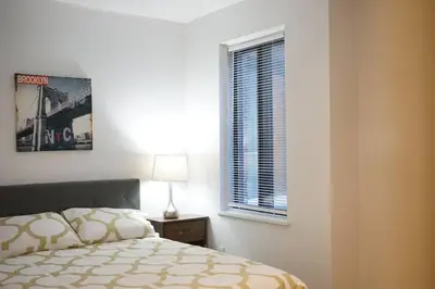 a bedroom with a bed and a window and a lamp at updated and cozy 2 bedroom unit, fully furnished, downtown, 32 days minimum in Montréal
