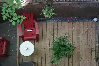 two red chairs and a table on a wooden fence at cute 2 bedroom unit, ground floor, downtown, 32 days minimum in Montréal