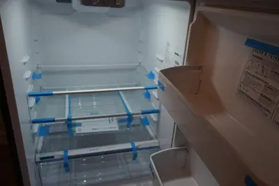 an empty refrigerator with blue tape on the door at cute 2 bedroom unit, ground floor, downtown, 32 days minimum in Montréal