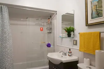 a white bathroom with a sink and a shower at cute 2 bedroom unit, ground floor, downtown, 32 days minimum in Montréal
