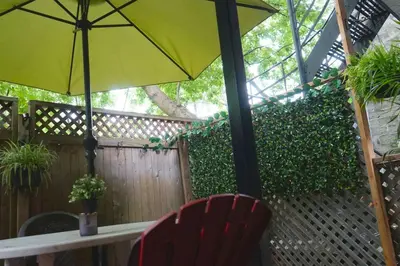 a yellow umbrella and a red chair on a patio at cute 2 bedroom unit, ground floor, downtown, 32 days minimum in Montréal