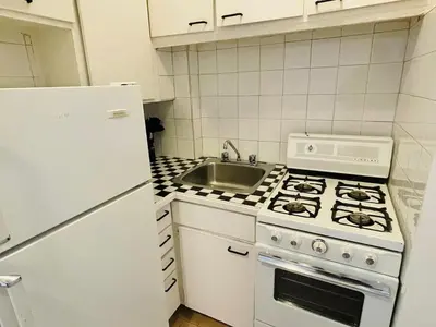 a kitchen with a white stove and a sink at Stylish Montreal Apartment Comfortable Stay in the Golden Square Mile in Montréal