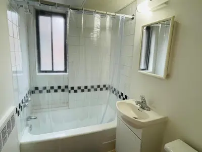 a white bathroom with a tub and a sink at Stylish Montreal Apartment Comfortable Stay in the Golden Square Mile in Montréal