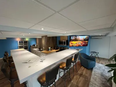a kitchen with a large white counter and chairs at Main Street in North Hatley