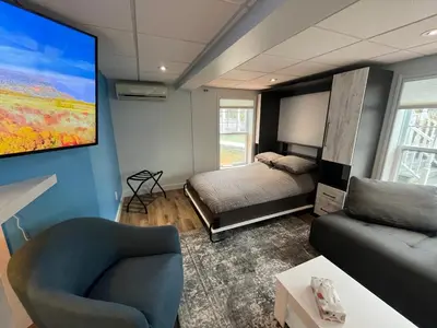 a room with a bed and a couch and a tv at Main Street in North Hatley