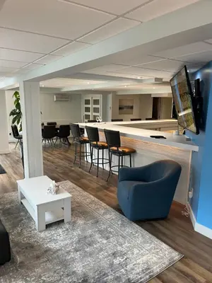 a living room with a bar with chairs and a table at Main Street in North Hatley
