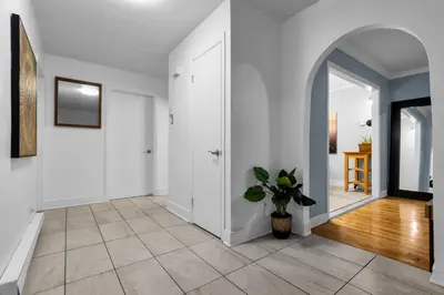 a hallway with white walls and a potted plant at COSY 3 BEDROOMS Montreal in Montréal
