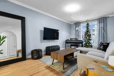 a living room with a couch and a table and a christmas tree at COSY 3 BEDROOMS Montreal in Montréal