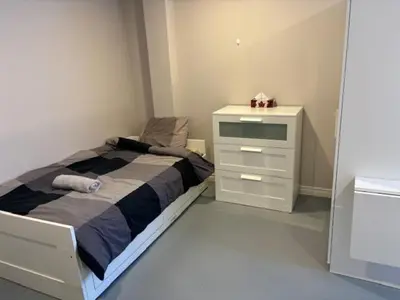 a small bedroom with a bed and a dresser at La maison internationale de Montréal in Montréal