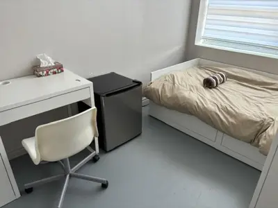 a bedroom with a desk and a bed and a chair at La maison internationale de Montréal in Montréal