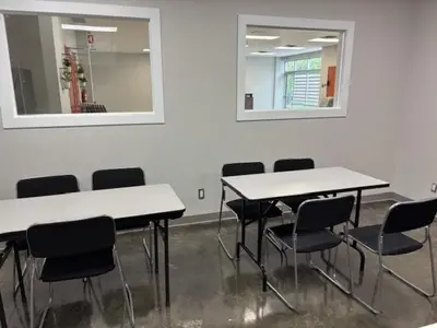 a room with white tables and chairs and two mirrors at La maison internationale de Montréal in Montréal