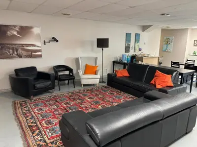 a living room with a couch and chairs and a rug at La maison internationale de Montréal in Montréal