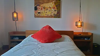 a bed with a red pillow on top of it at Urbanity et cosy in Montréal
