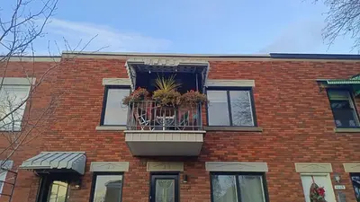 a brick building with a balcony with flowers in it at Urbanity et cosy in Montréal