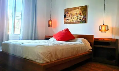 a bedroom with a bed with a red pillow at Urbanity et cosy in Montréal