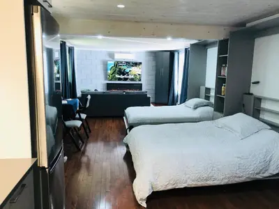 a bedroom with two beds and a living room at Le Loft in North Hatley