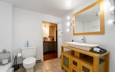 a bathroom with a sink and a toilet and a mirror at Le Loft in North Hatley