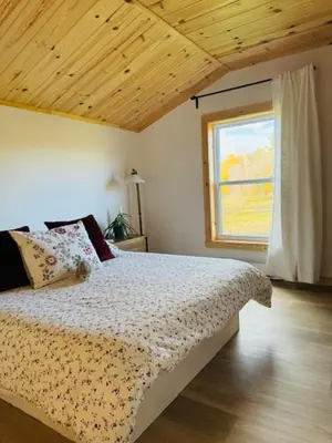 a bedroom with a large bed with a window at Le Garage 17 in Frelighsburg