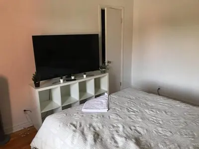 a bedroom with a large flat screen tv on the wall at Chambre spacieuse in Montréal