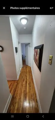 a hallway of a home with wooden floors and a painting at Chambre spacieuse in Montréal